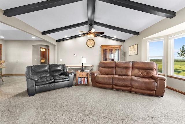 carpeted living room with ceiling fan and lofted ceiling with beams