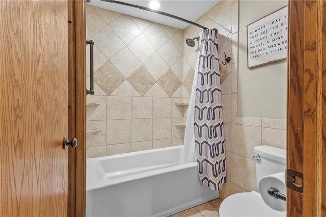 bathroom featuring shower / bath combo, toilet, and tile walls