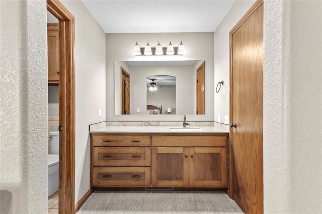 bathroom with ceiling fan, vanity, and toilet