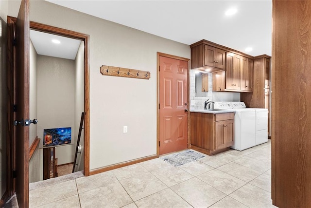 kitchen featuring decorative backsplash, sink, light tile patterned flooring, and independent washer and dryer