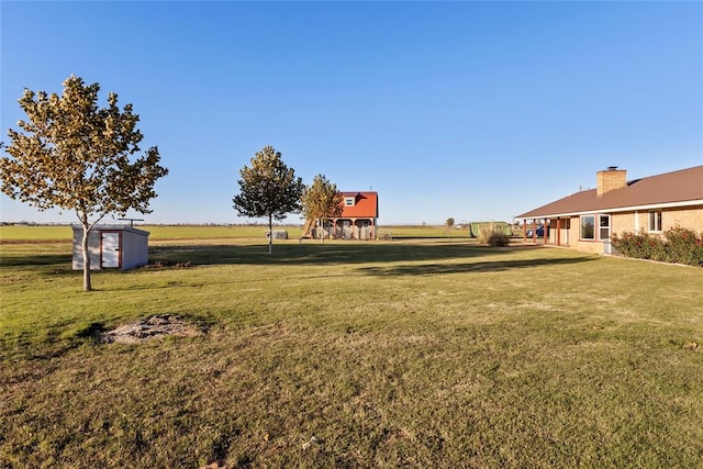 view of yard featuring a rural view and a shed