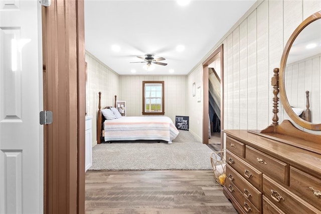 bedroom with hardwood / wood-style floors, ceiling fan, and ornamental molding