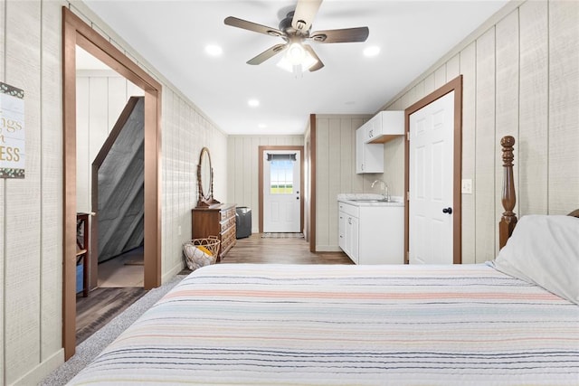 bedroom with ensuite bathroom, sink, ceiling fan, and hardwood / wood-style flooring