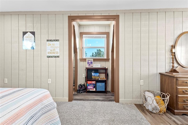 bedroom featuring wood-type flooring and wooden walls