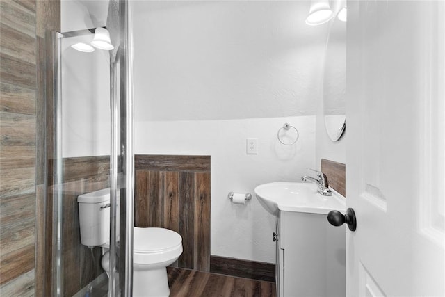 bathroom with an enclosed shower, vanity, toilet, and wood-type flooring