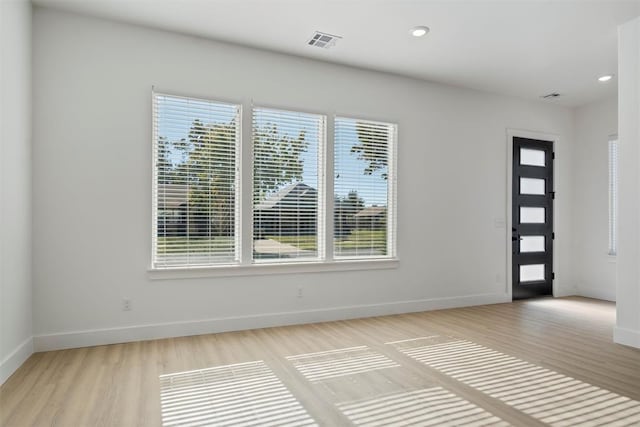 foyer entrance with light hardwood / wood-style flooring and a healthy amount of sunlight