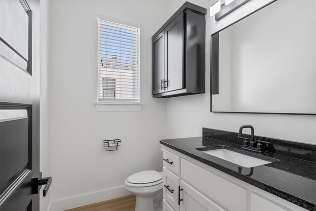 bathroom featuring wood-type flooring, vanity, and toilet