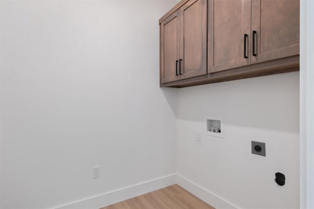 washroom featuring cabinets, washer hookup, light hardwood / wood-style flooring, and hookup for an electric dryer