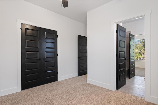 foyer with ceiling fan and light carpet