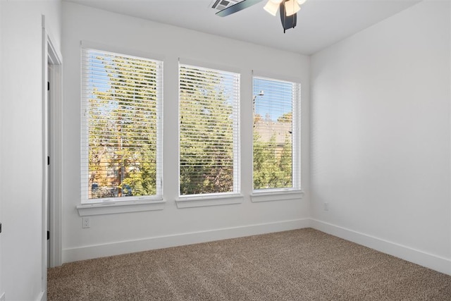 carpeted spare room with a wealth of natural light and ceiling fan