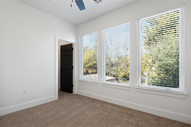 carpeted spare room featuring ceiling fan