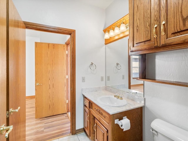 bathroom with hardwood / wood-style floors, vanity, and toilet