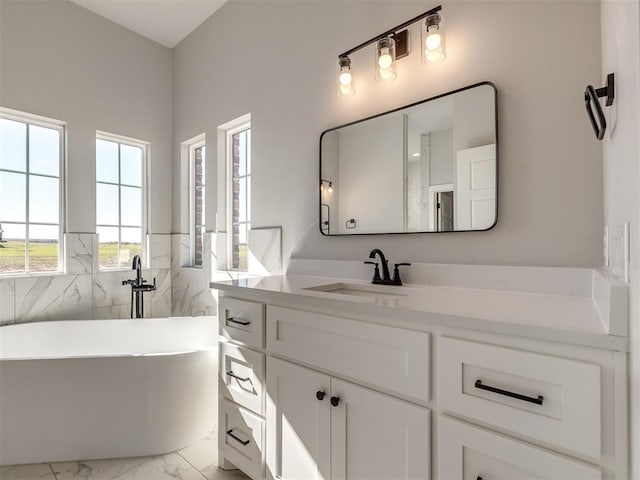 bathroom with a washtub, vanity, and tile walls