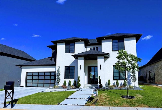 prairie-style house featuring a front lawn and a garage