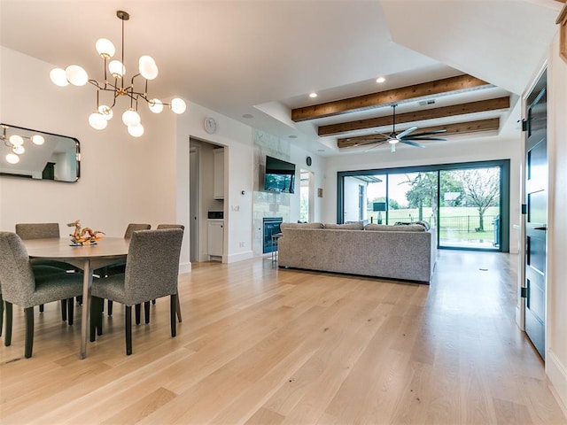 dining space featuring beamed ceiling, ceiling fan with notable chandelier, and light hardwood / wood-style floors