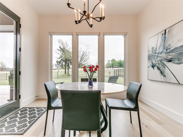 dining area with a notable chandelier and light hardwood / wood-style flooring