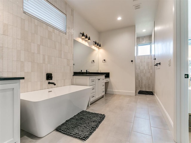 bathroom with tile patterned flooring, vanity, separate shower and tub, and tile walls