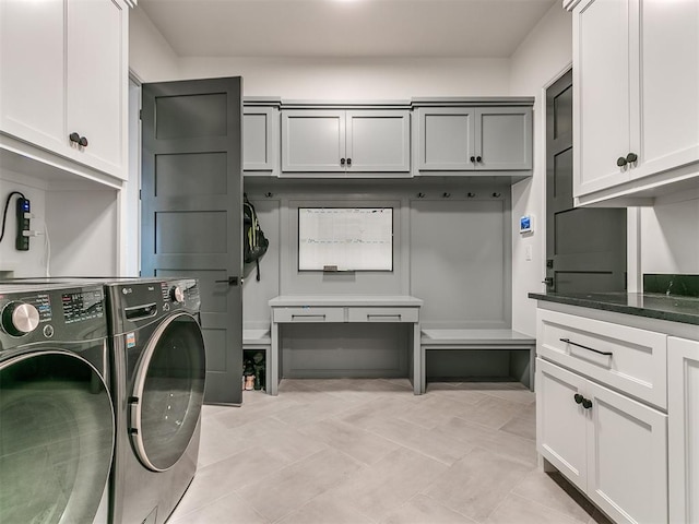 clothes washing area with cabinets and washing machine and dryer