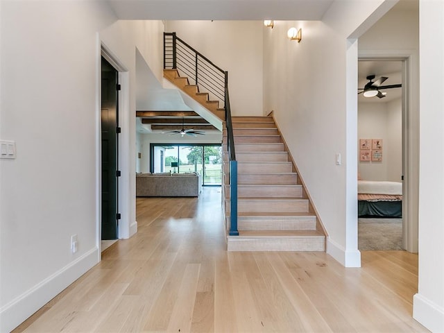 stairway featuring hardwood / wood-style flooring and ceiling fan