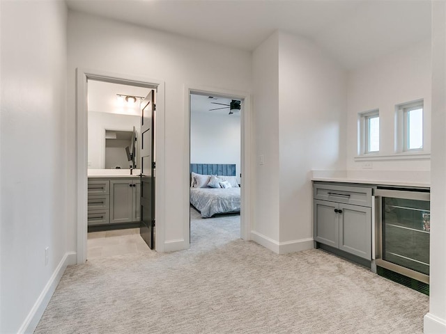 interior space featuring vanity, ceiling fan, and beverage cooler