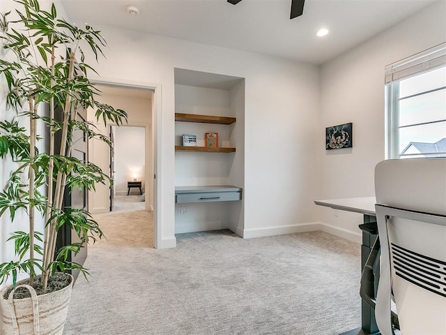 carpeted home office with ceiling fan