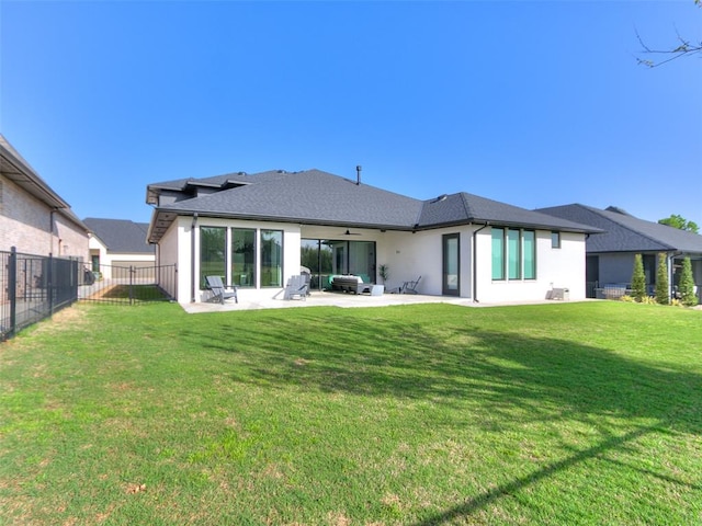 back of property with a yard, a patio, and ceiling fan