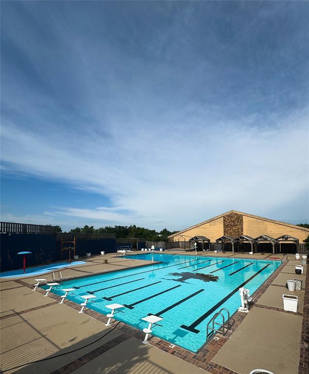 view of swimming pool with a diving board and a patio area