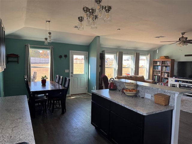 kitchen featuring pendant lighting, dark wood-type flooring, and vaulted ceiling