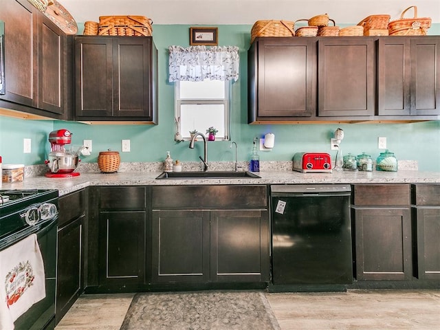 kitchen with dark brown cabinetry, sink, light stone counters, light hardwood / wood-style flooring, and black appliances