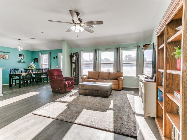 living room with ceiling fan, dark wood-type flooring, and vaulted ceiling