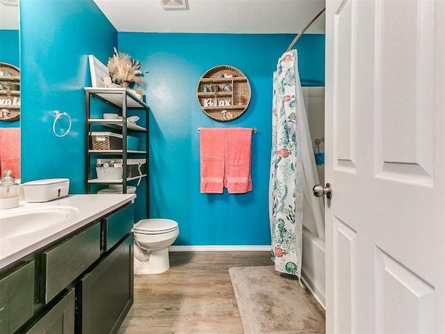 full bathroom with wood-type flooring, vanity, toilet, and shower / tub combo with curtain