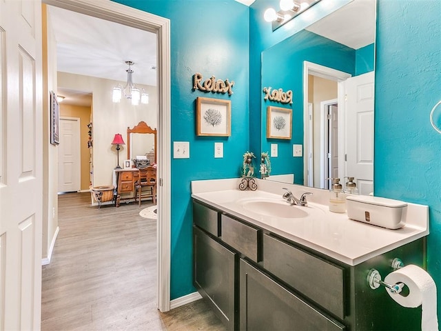 bathroom featuring a notable chandelier, vanity, and wood-type flooring