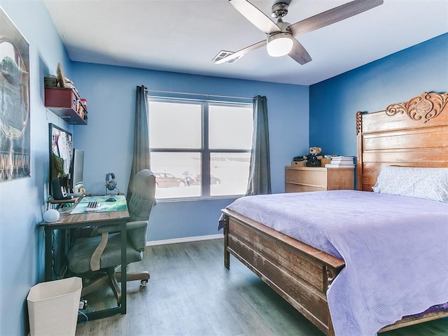 bedroom with dark hardwood / wood-style flooring and ceiling fan