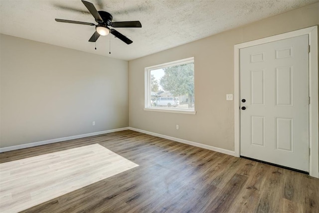 empty room with ceiling fan, hardwood / wood-style floors, and a textured ceiling