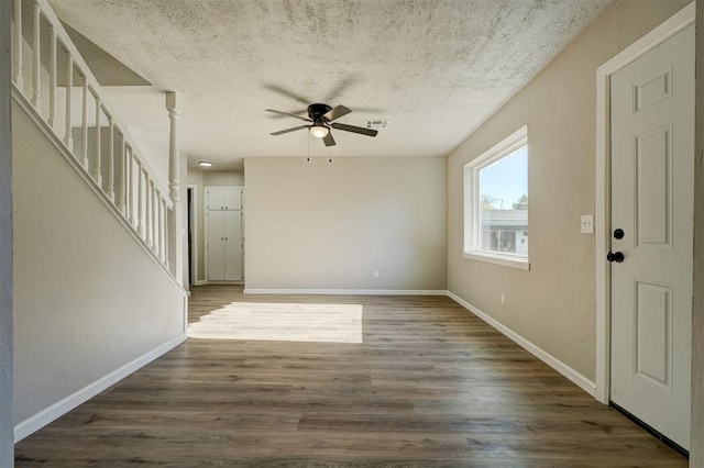 interior space with ceiling fan, dark hardwood / wood-style flooring, and a textured ceiling