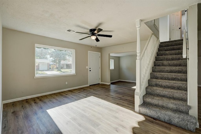 entryway with a textured ceiling, ceiling fan, and dark wood-type flooring