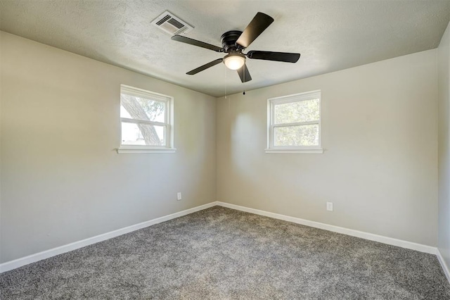 carpeted empty room featuring a textured ceiling, ceiling fan, and a healthy amount of sunlight