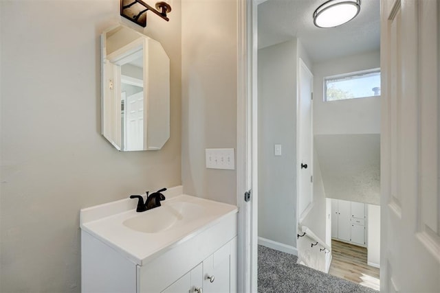 bathroom featuring vanity, wood-type flooring, and a textured ceiling