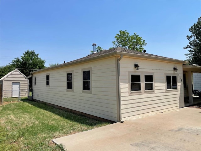 view of side of home with a lawn and a patio area