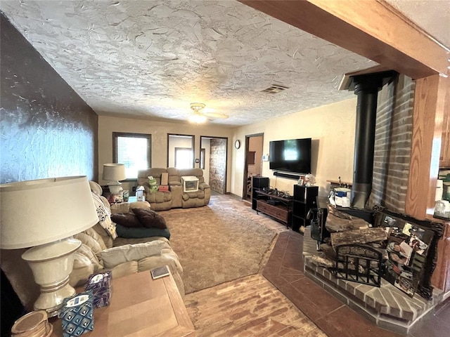 living room featuring a textured ceiling and a wood stove