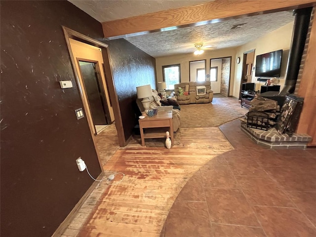 living room featuring tile patterned flooring, beamed ceiling, and a textured ceiling