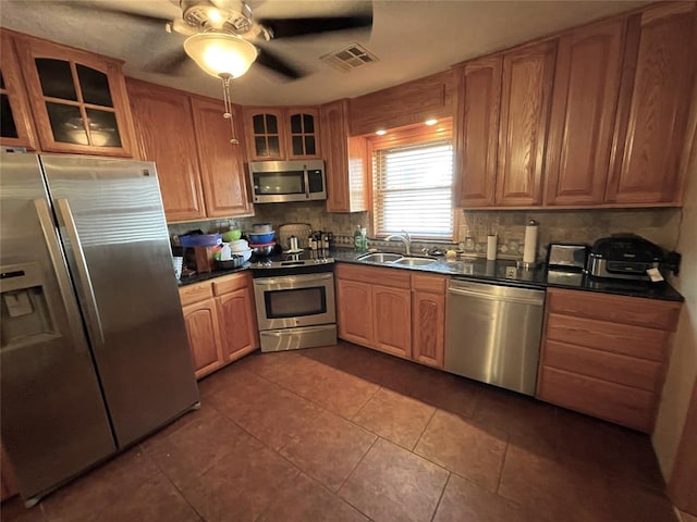 kitchen with ceiling fan, sink, backsplash, dark tile patterned flooring, and appliances with stainless steel finishes