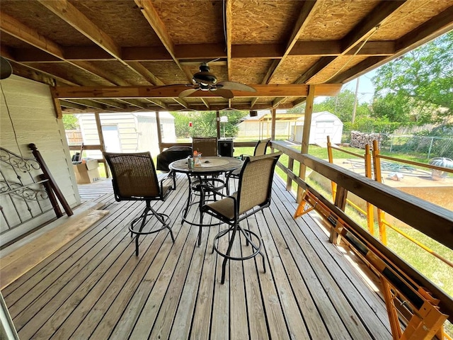 wooden deck featuring a storage unit and ceiling fan