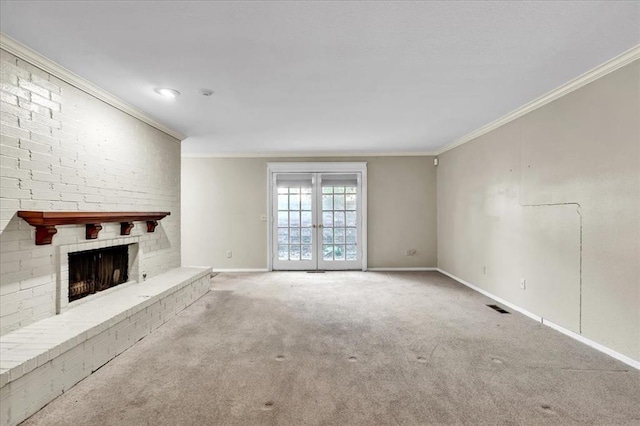 unfurnished living room with ornamental molding, carpet floors, a fireplace, and french doors