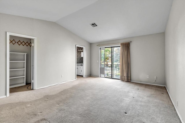 empty room featuring light carpet and lofted ceiling