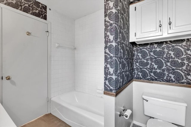 bathroom featuring toilet and tiled shower / bath