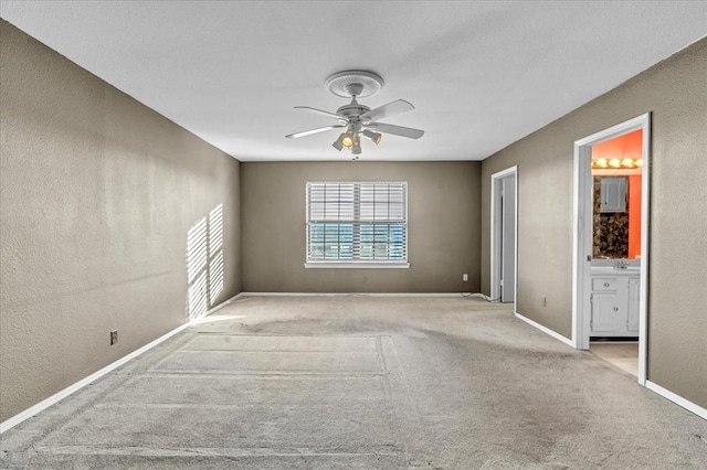 carpeted spare room with ceiling fan