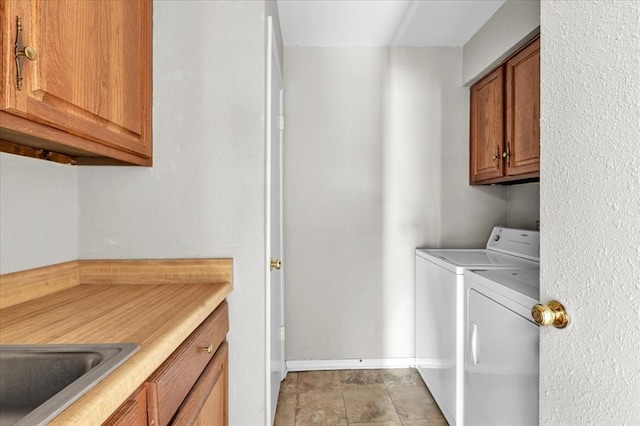 washroom with separate washer and dryer, sink, light tile patterned floors, and cabinets