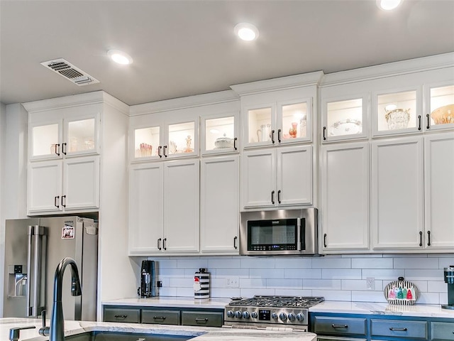 kitchen with white cabinetry, appliances with stainless steel finishes, sink, and tasteful backsplash