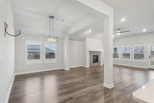 unfurnished living room featuring lofted ceiling, dark wood-type flooring, a wealth of natural light, and ceiling fan